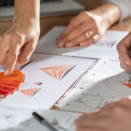 foto de dois pares de mãos desenhando no papel e criando logotipos e identidades visuais