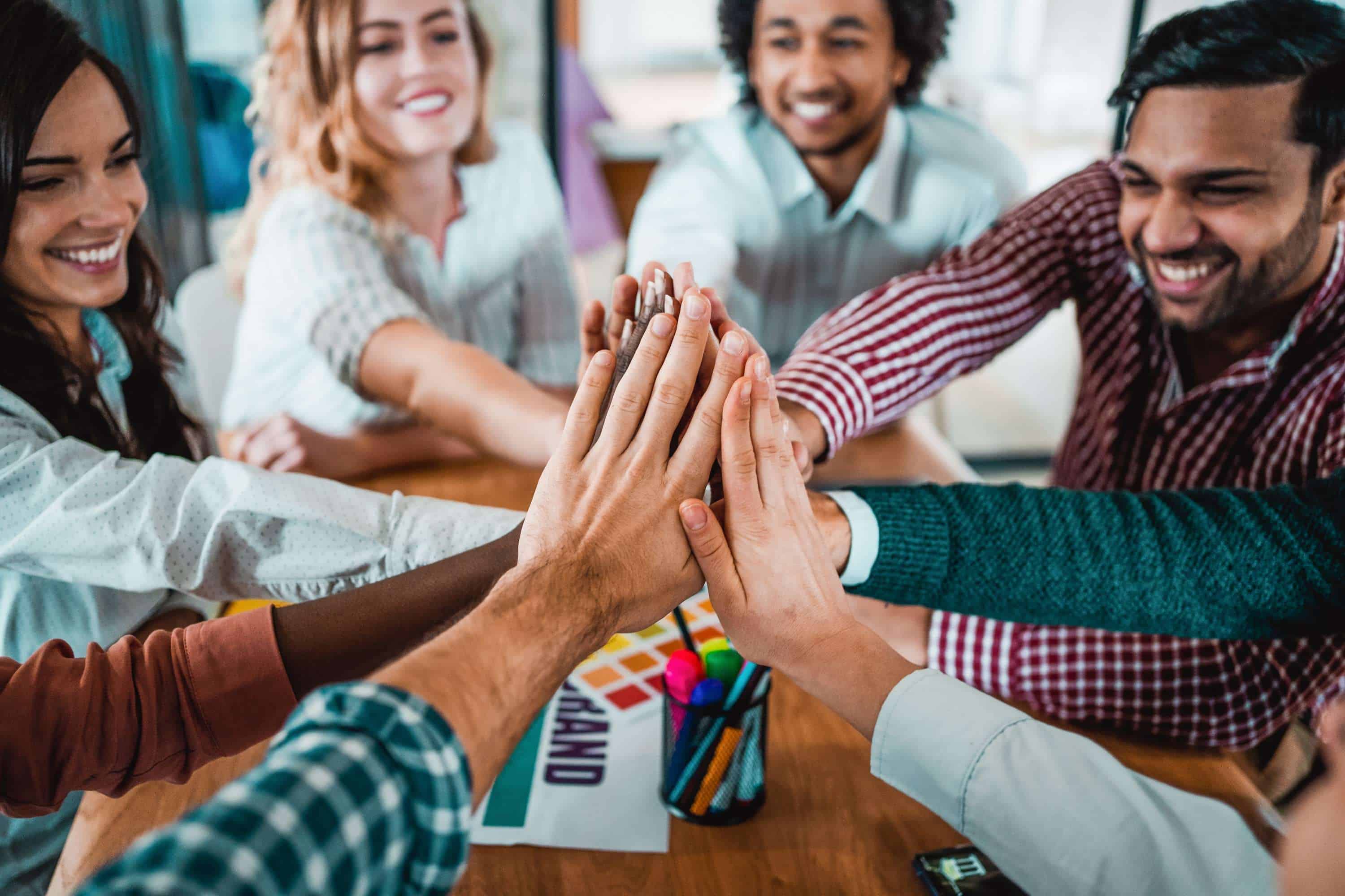 imagem mostrando equipe de trabalho batendo as mãos, reproduzindo a união colaboradores no branding.