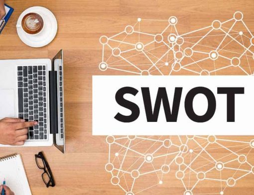 mesa-de-madeira-com computador-e escrito swot na mesa