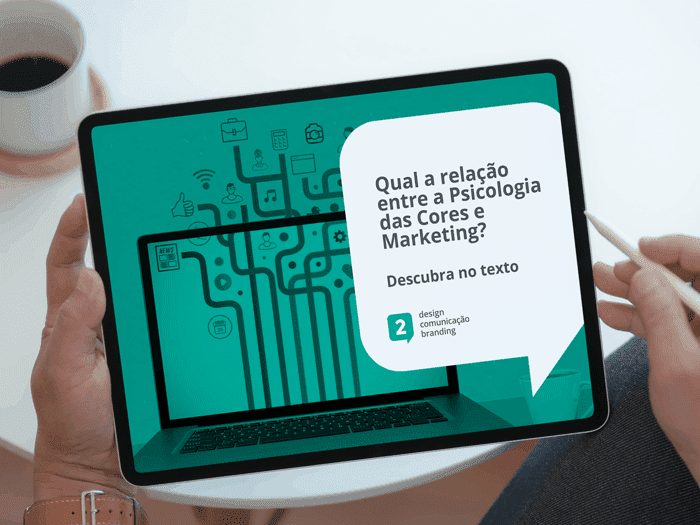 Imagem pessoa segurando um tablet, na tela um desenho sobre marketing sobreposto de um filtro verde com o descritivo "qual a relação entre a psicologia das cores e o marketing? Descubra no texto