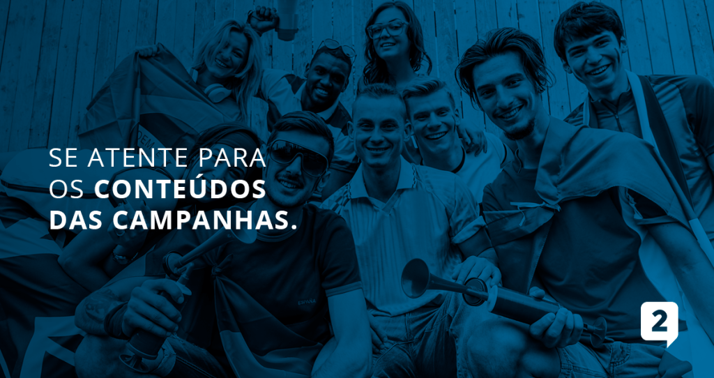 A imagem apresenta um grupo de torcedores com bandeiras do brasil e buzinas e a seguinte frase descrita ao lado: "Se atenta para os conteúdos das campanhas."